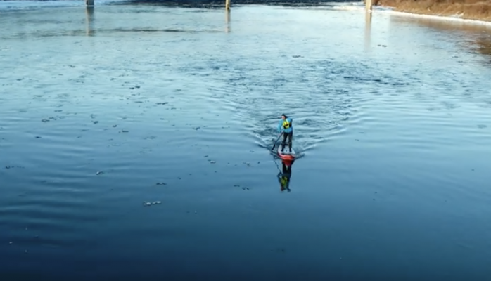 Stand-up paddleboarder hits the river all winter long